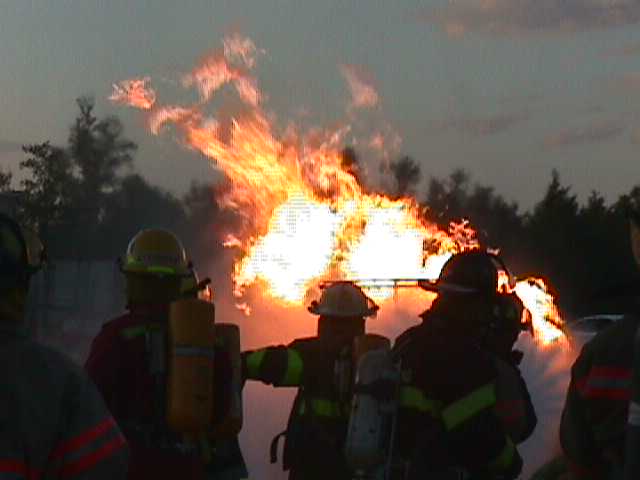 Firefighters attacking a simulate Class B (propane) fire